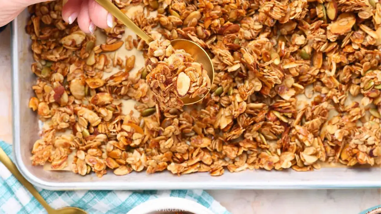 Goldene Löffelprobe von knusprigem, hausgemachtem Granola ohne Zucker, voller Nüsse und Samen.