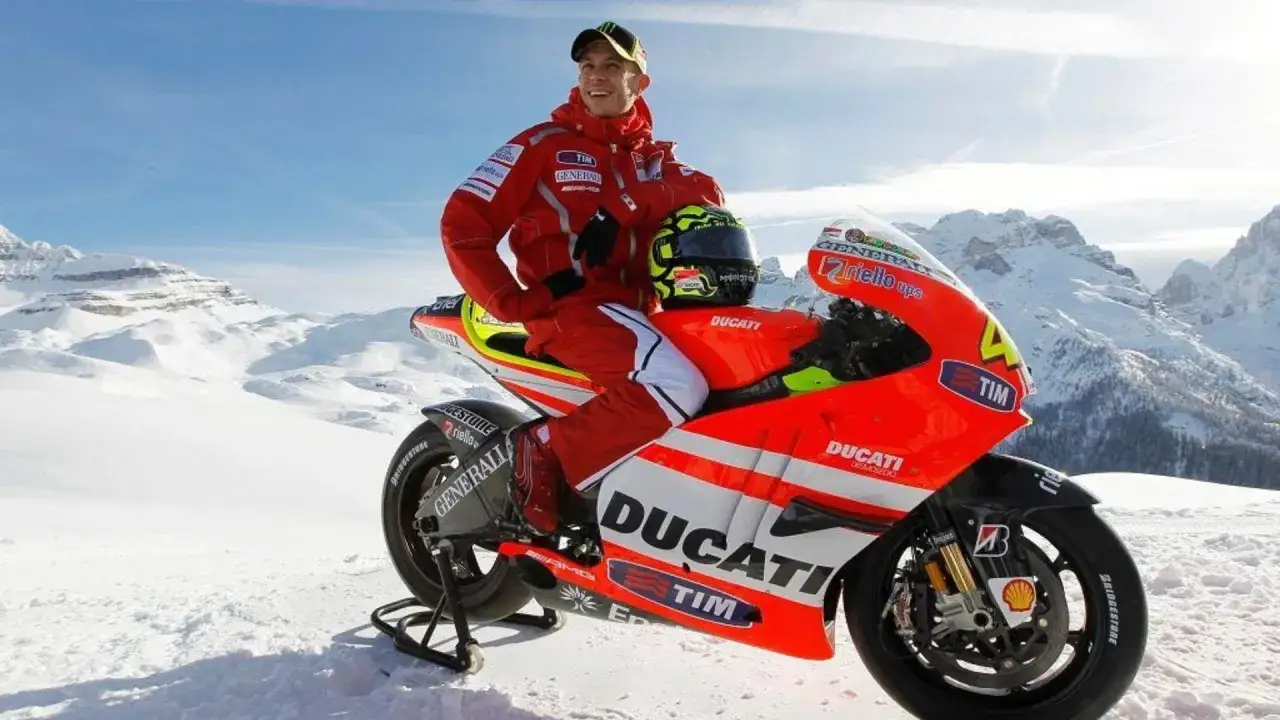 Valentino Rossi posa con su moto Ducati en un paisaje nevado.
