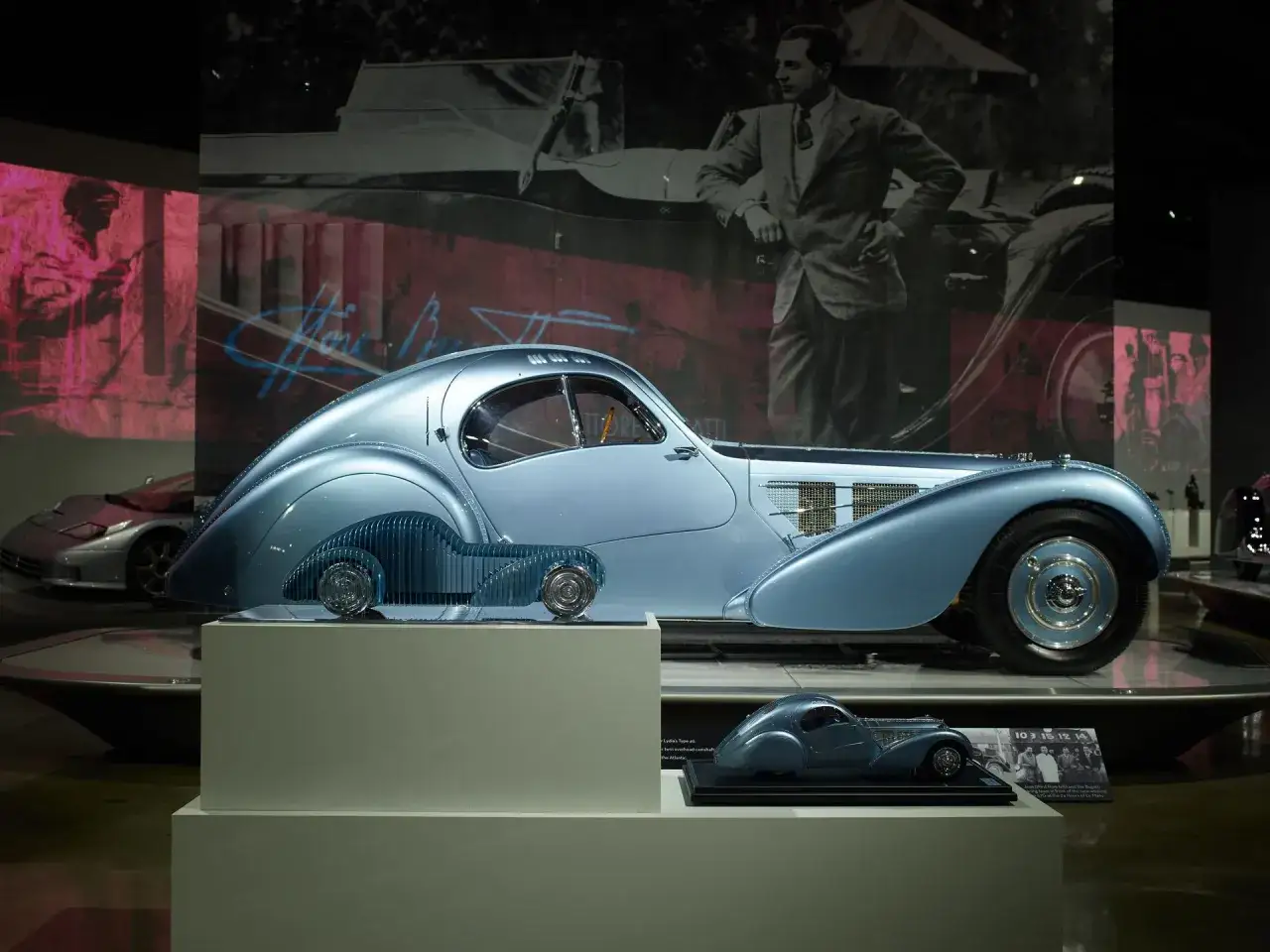Ein blauer Bugatti Type 57SC Atlantic, ein Meisterwerk der Automobilgeschichte, dessen schlumpf autosammlung wert unbezahlbar ist. Daneben ein Modell.