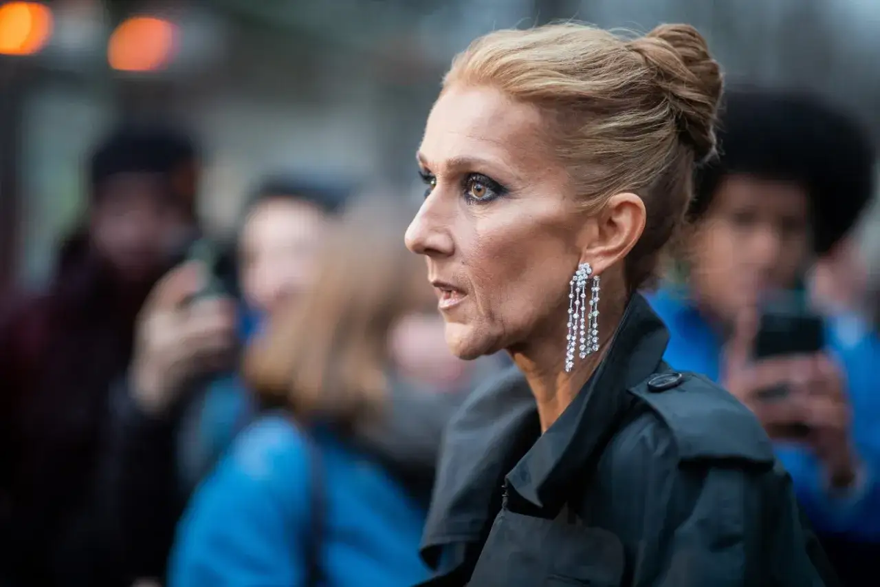 Celine Dion w eleganckiej stylizacji, z błyszczącymi kolczykami, w otoczeniu tłumu. Co się dzieje z Celine Dion?
