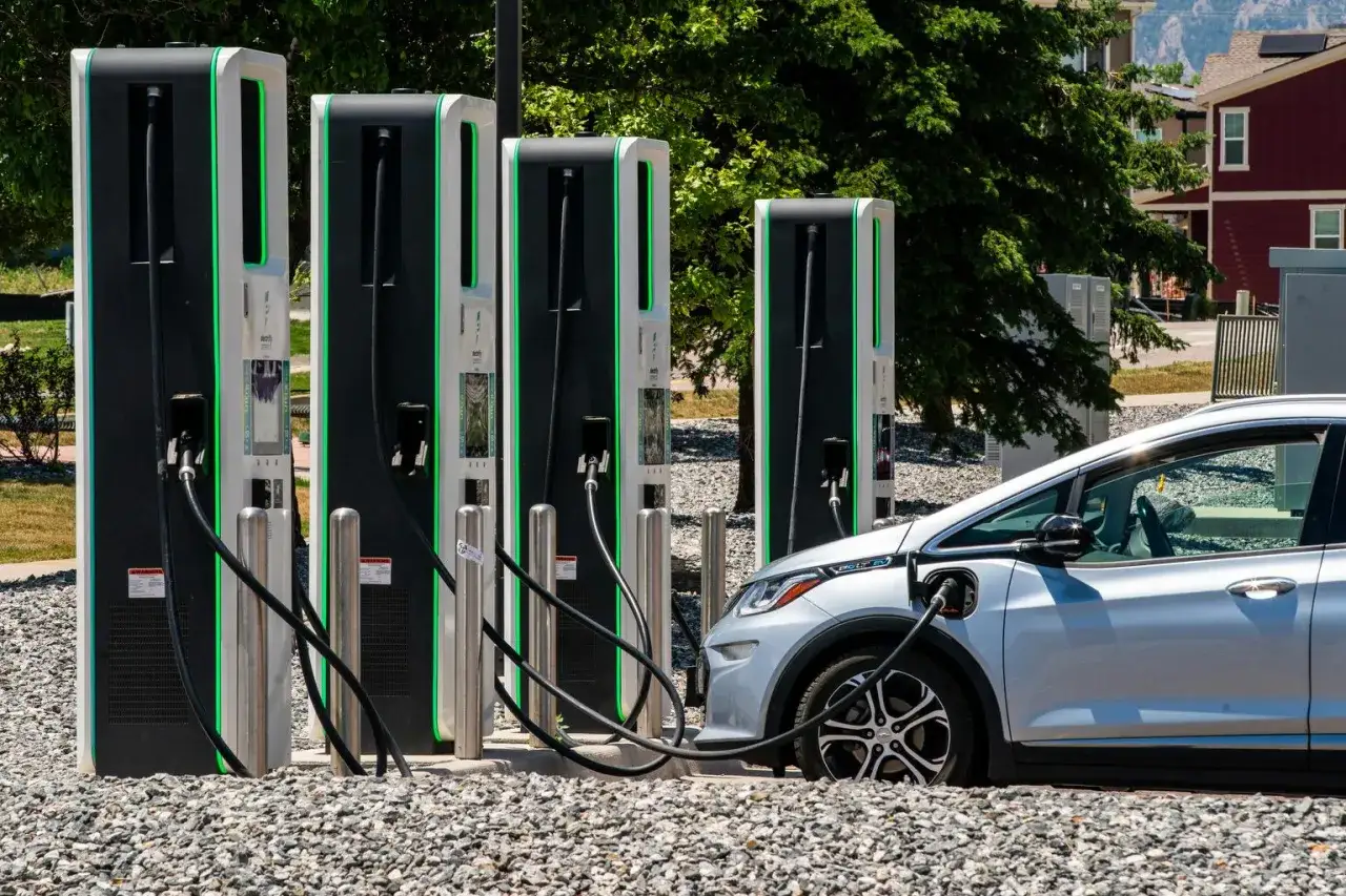 Stazione di ricarica per auto elettriche con colonnine moderne e un'auto in carica. La ricarica veloce è pronta per il tuo viaggio.