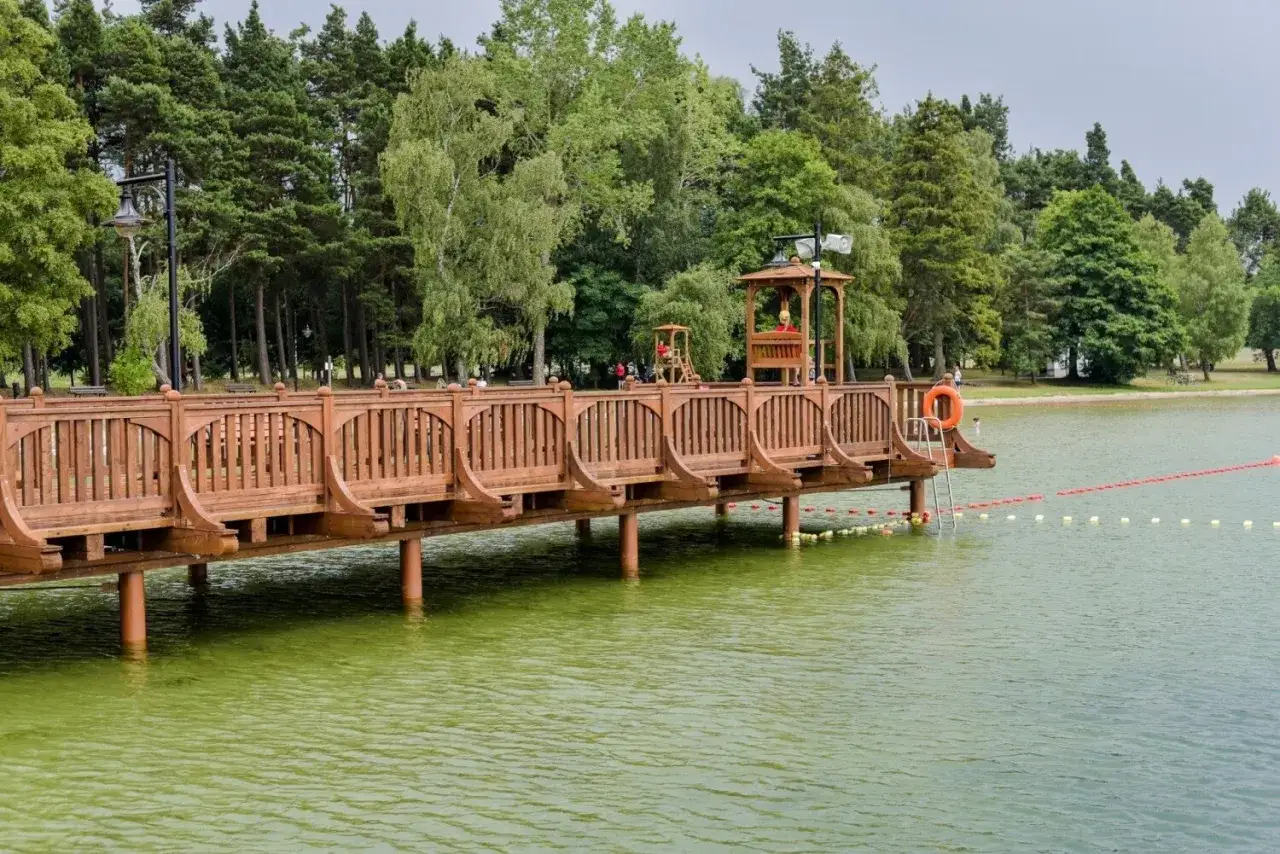 Drewniany pomost na jeziorze wielewskim, z wieżą ratownika i linią bojki.