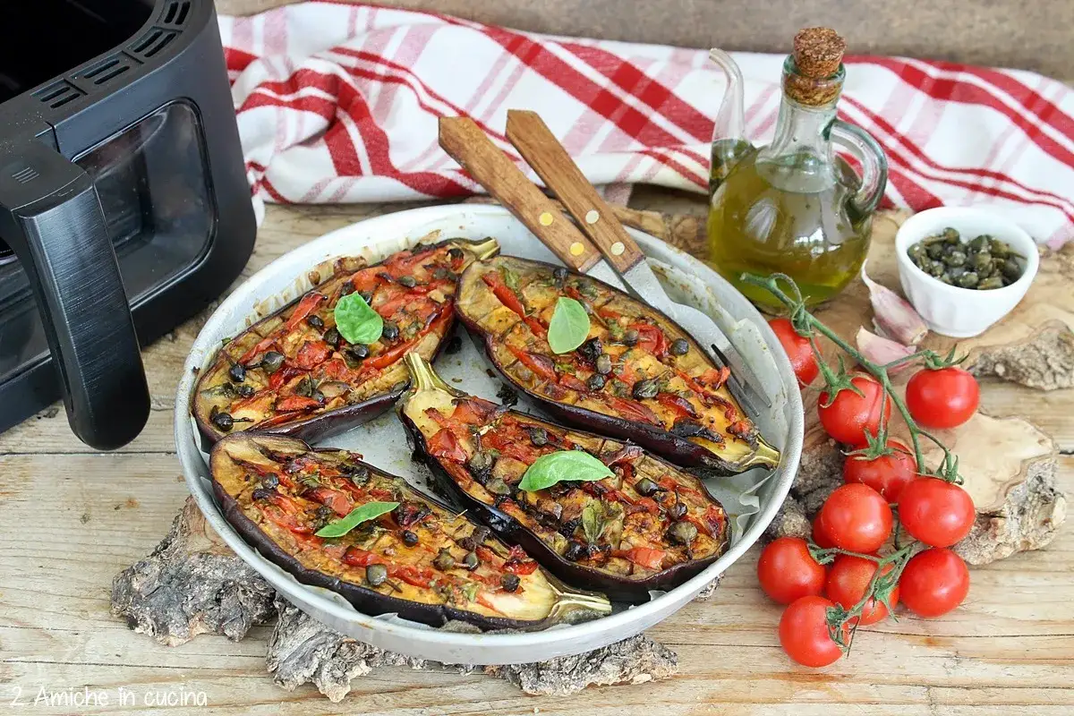 Melanzane ripiene cotte nella friggitrice ad aria, condite con pomodorini, capperi e basilico. Un piatto saporito e leggero.