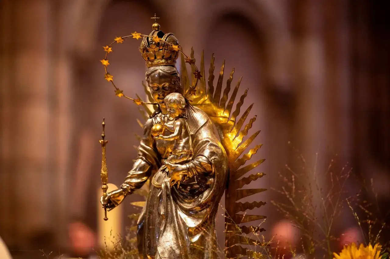 Goldene Statue der Maria mit Kind, gekr&ouml;nt und mit Sternenreigen. Ein Symbol f&uuml;r Maria Namen und g&ouml;ttliche Liebe.