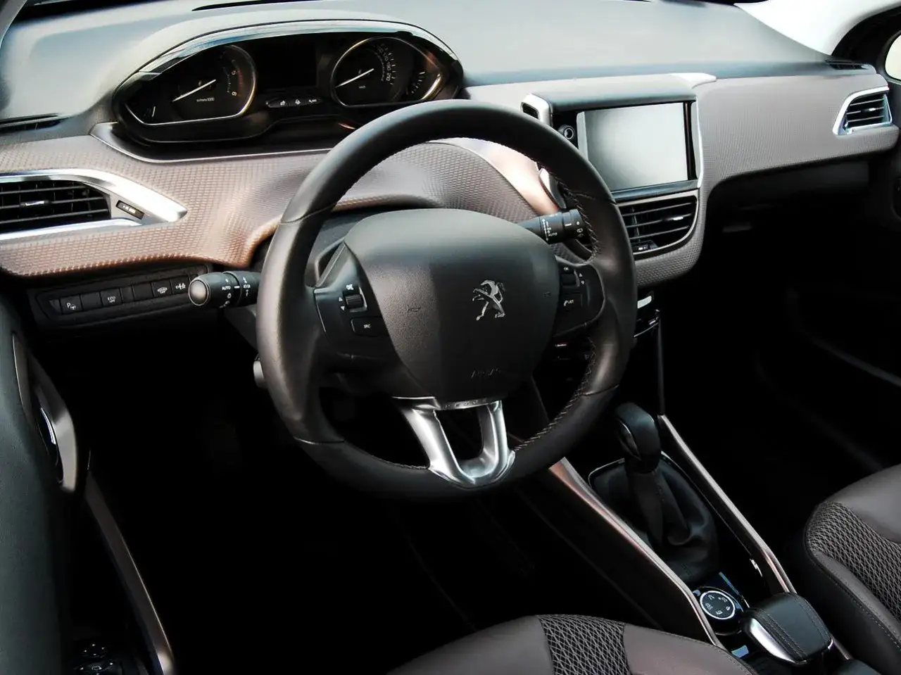 Wnętrze 2008 Peugeot z kierownicą, deską rozdzielczą i ekranem dotykowym.