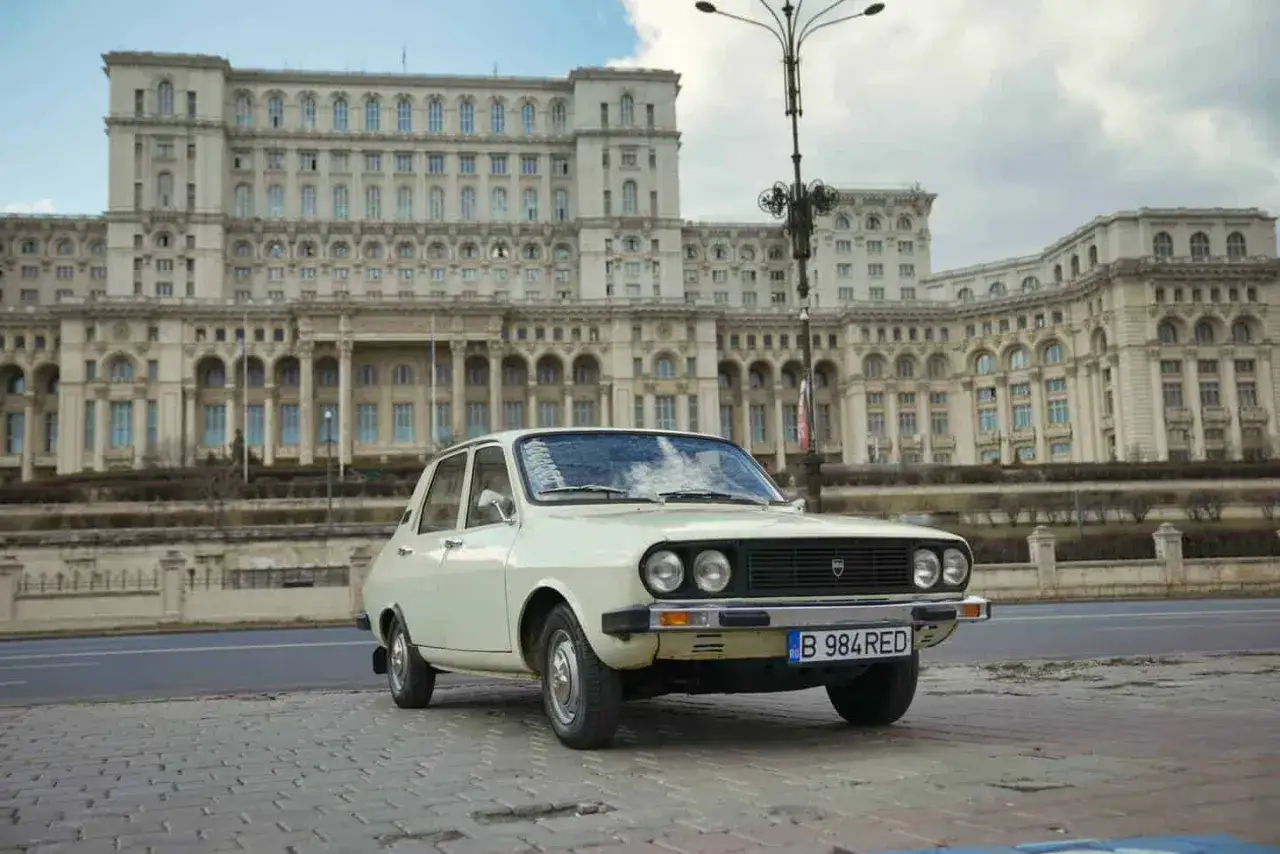 Biała Dacia 1300 na tle monumentalnego Pałacu Parlamentu w Bukareszcie.