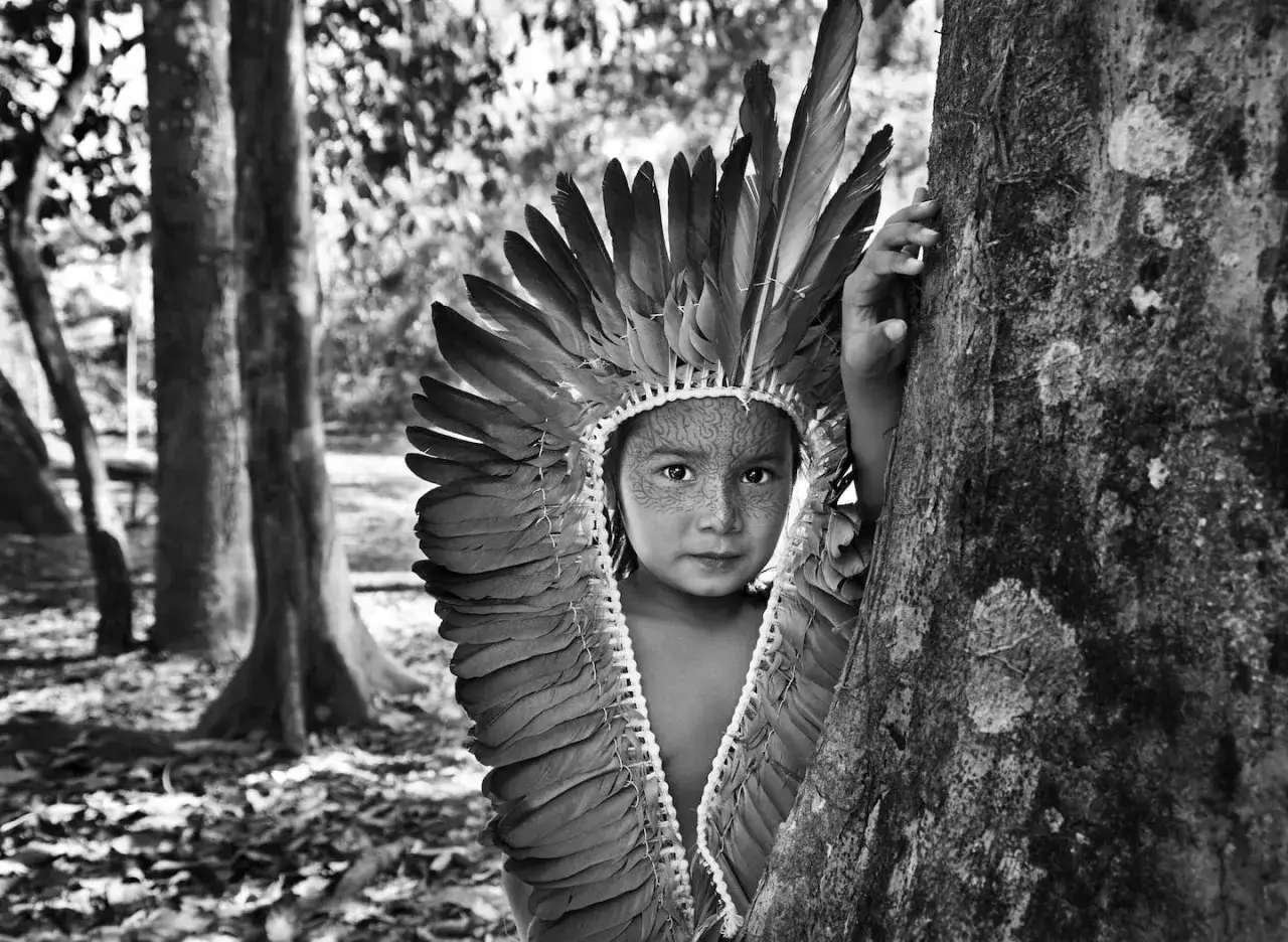 Dziecko z pi&oacute;ropuszem, twarz ozdobiona wzorami, jak uwiecznił Sebastiao Salgado.