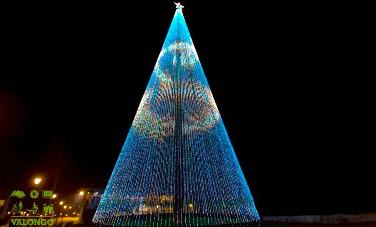 Gigantesco árbol de Navidad en Vigo, cubierto de miles de luces azules y doradas, brillando en la noche.