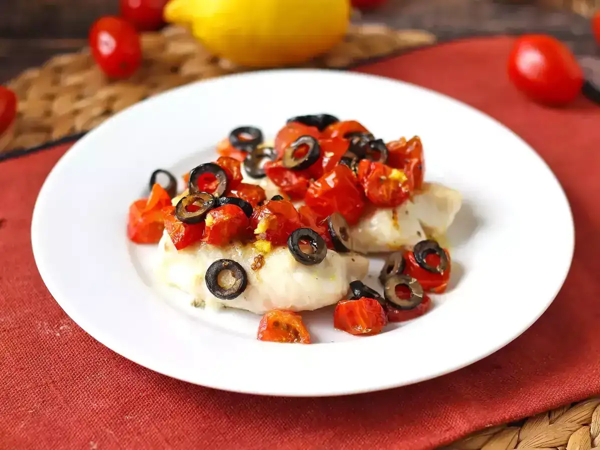 Delizioso merluzzo in friggitrice ad aria, condito con pomodorini e olive nere. Un piatto leggero e gustoso.