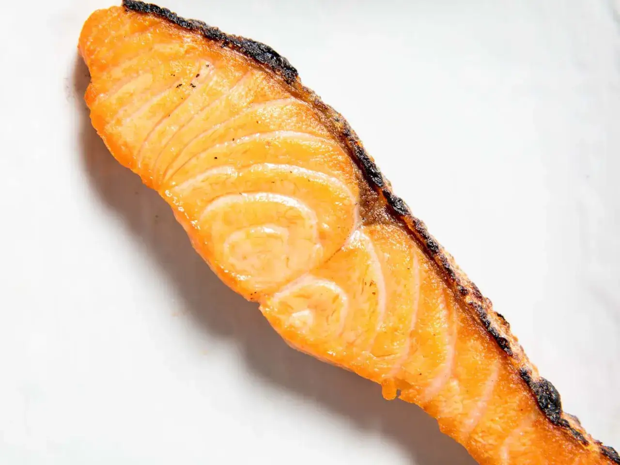 A perfectly cooked, golden-orange salmon fillet with crispy, seared edges, ready for a delicious salted salmon recipe.