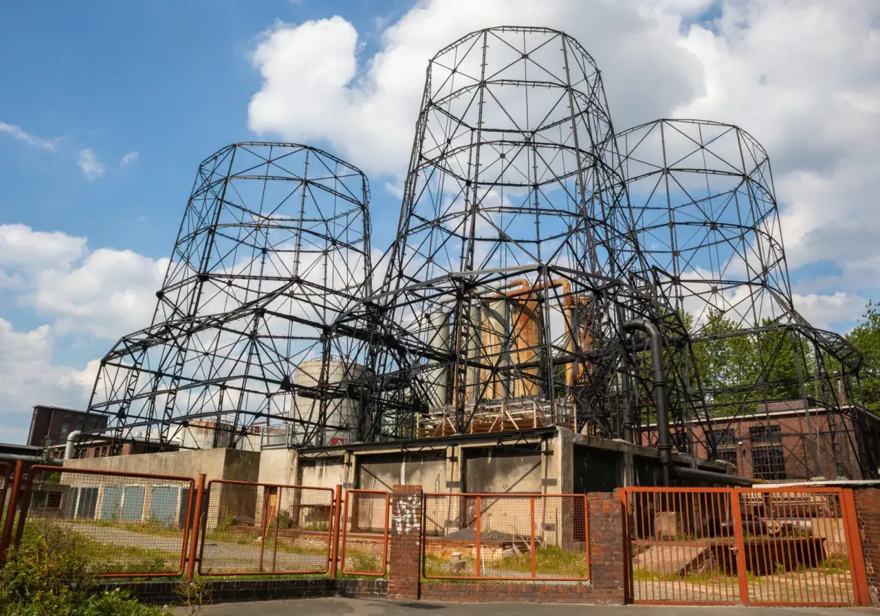 Drei riesige, gusseiserne Gerüste ragen in den blauen Himmel. Die Kokerei Hansa, ein Lost Place, zeigt ihre beeindruckende, rostige Struktur.