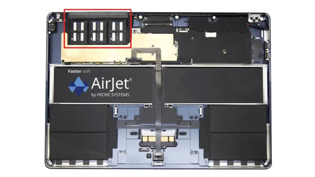 Wnętrze laptopa z widocznym procesorem M2, baterią AirJet i innymi komponentami.