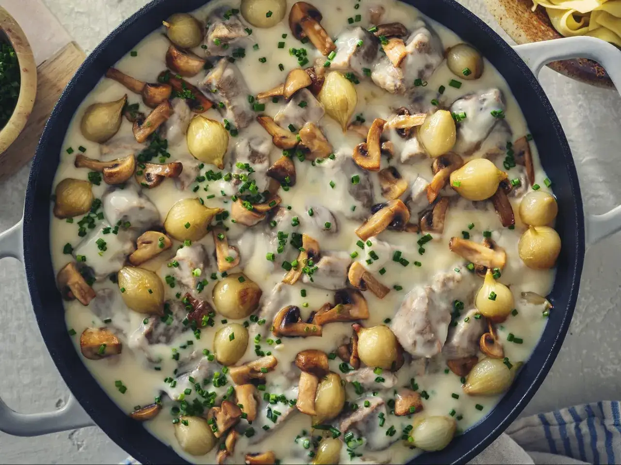 Blanquette de veau cr&eacute;meuse avec champignons et petits oignons, une v&eacute;ritable recette pour un plat r&eacute;confortant.