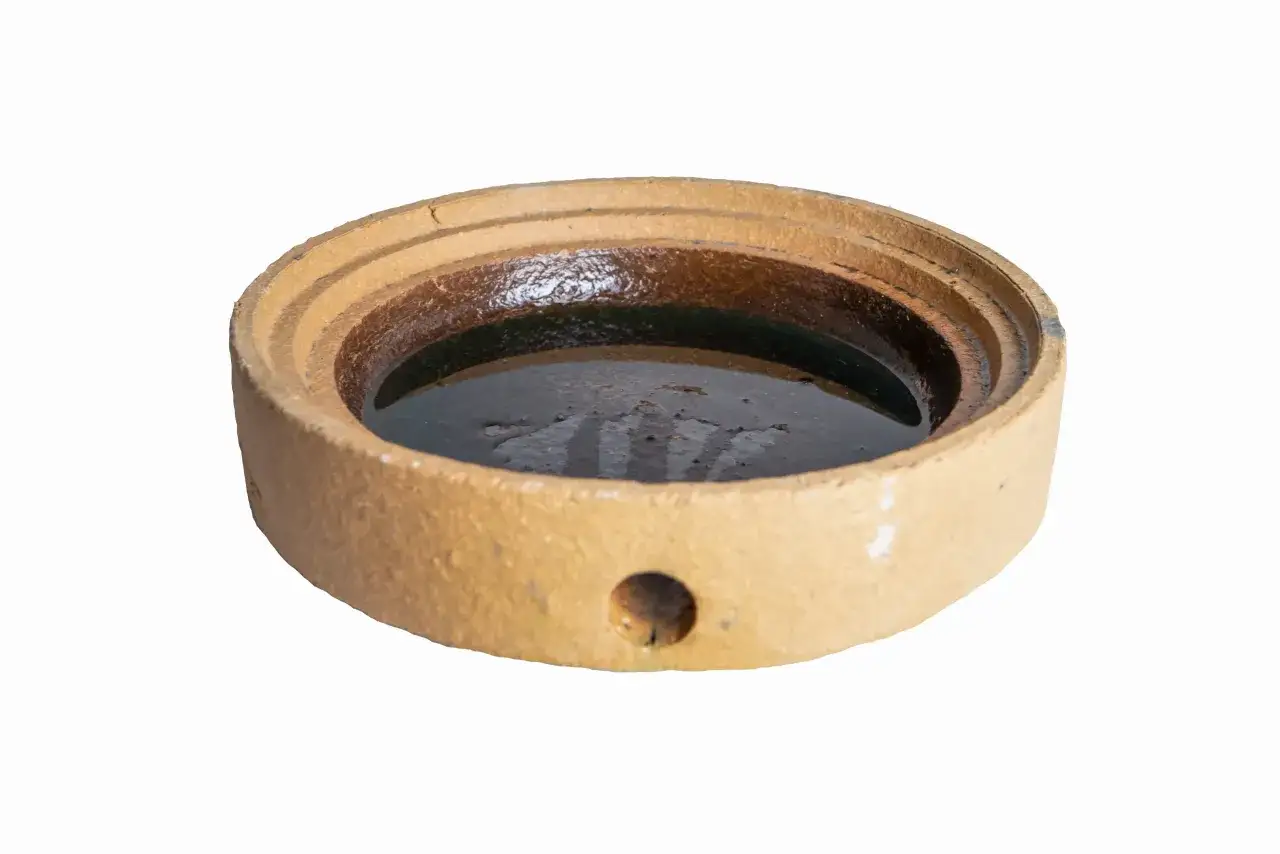 Ceramiczna podstawka z wodą, idealna do zbierania skroplin z komina.