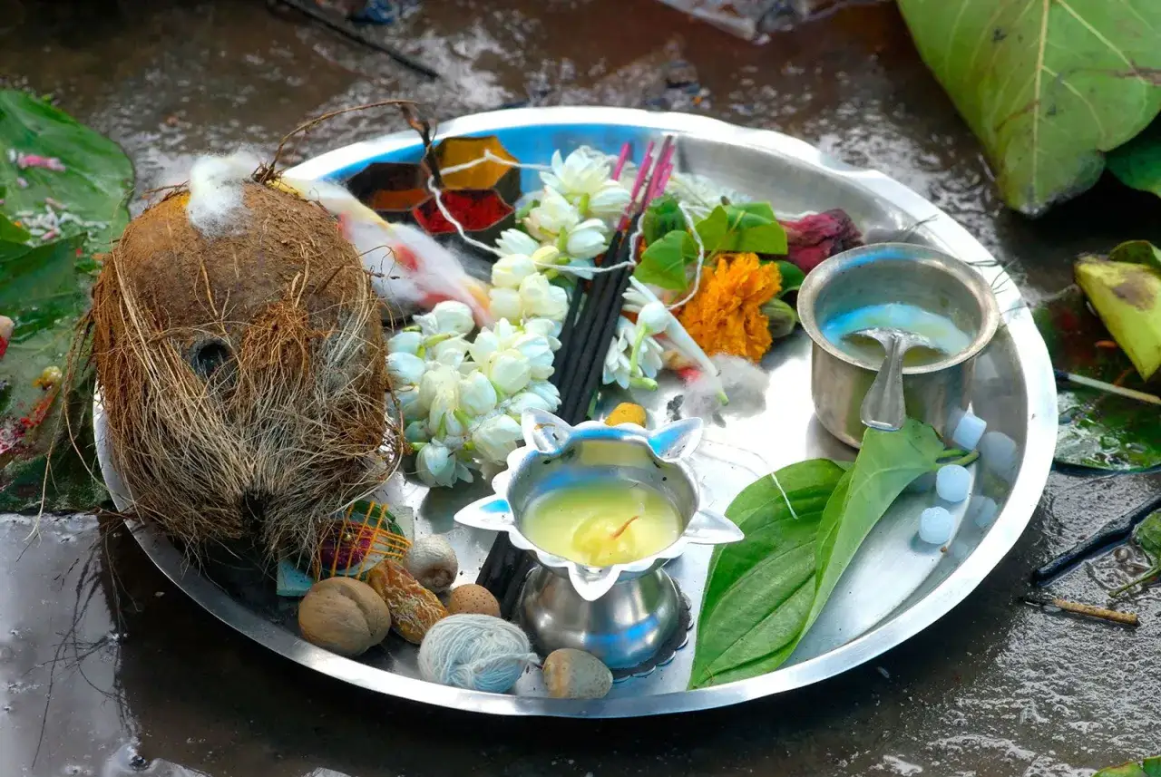 En bricka för puja, med kokosnöt, blommor, rökelsepinnar och en oljelampa. Detta är en del av vad som betyder puja.