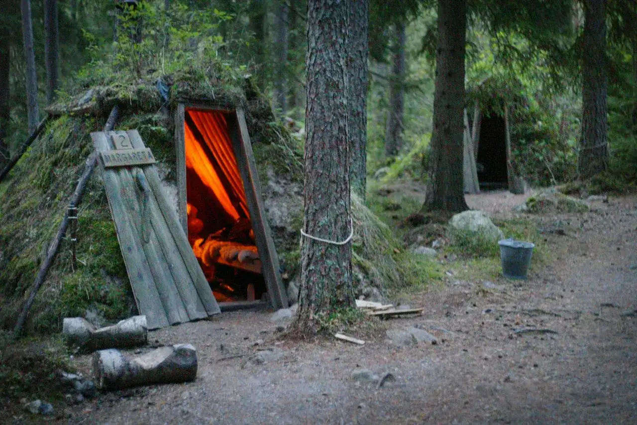 Ett annorlunda hotell i Sverige: en mysig jordkula med orange ljus som lyser från öppningen.