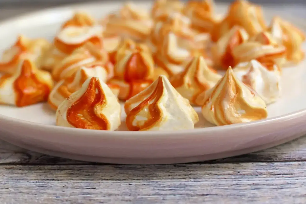Zarte Baiser-Häppchen mit orangen Wirbeln, perfekt für ein einfaches Baiser Rezept.