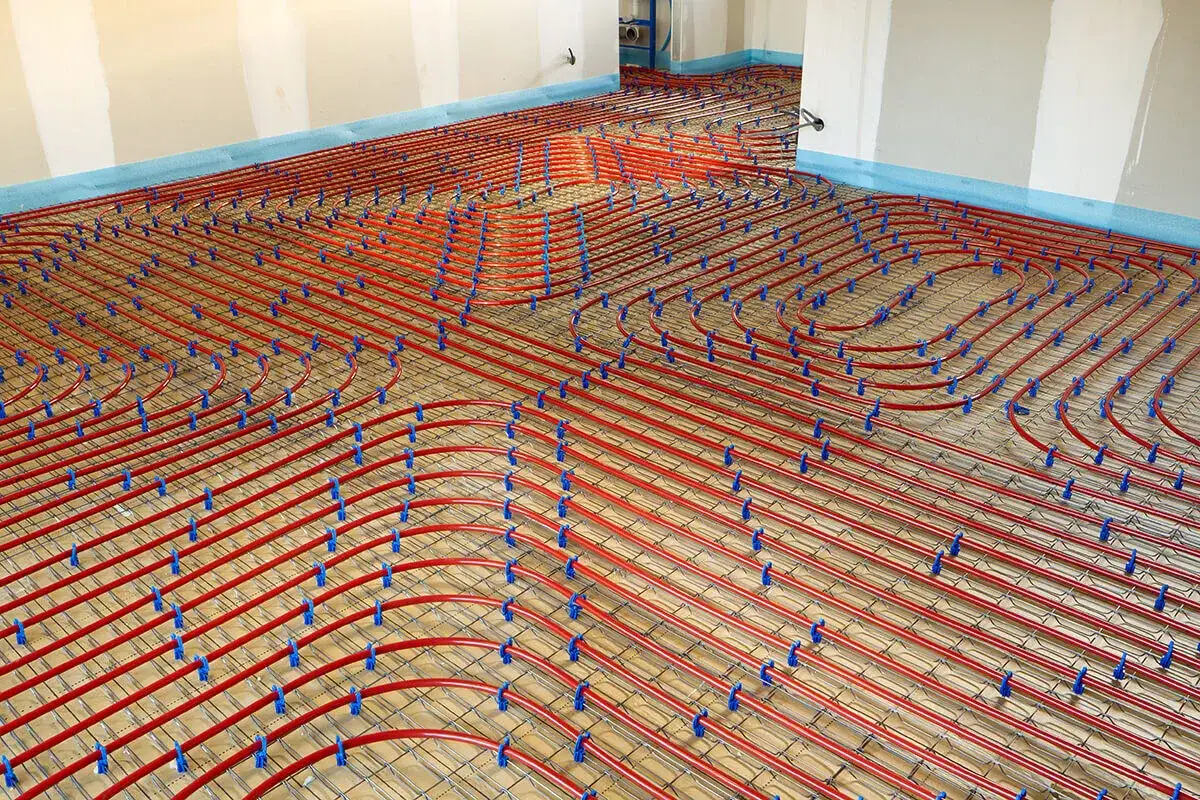 Installation de tubes rouges pour chauffage au sol, prêts à être recouverts. Le chauffage au sol interdit n'est pas une option ici, c'est une installation moderne.