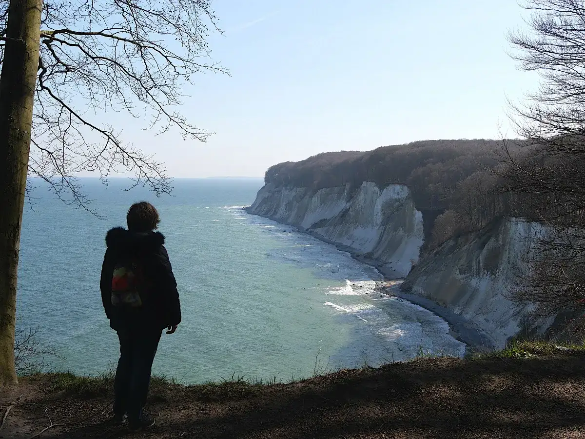 Blick auf die Kreidefelsen bei Sassnitz. Ein Wanderer genießt die Aussicht auf das Meer. Ein Muss für Sassnitz Tourismus.
