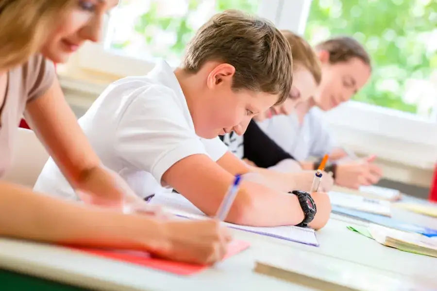 Dziecko zdające egzamin, uczeń piszący test