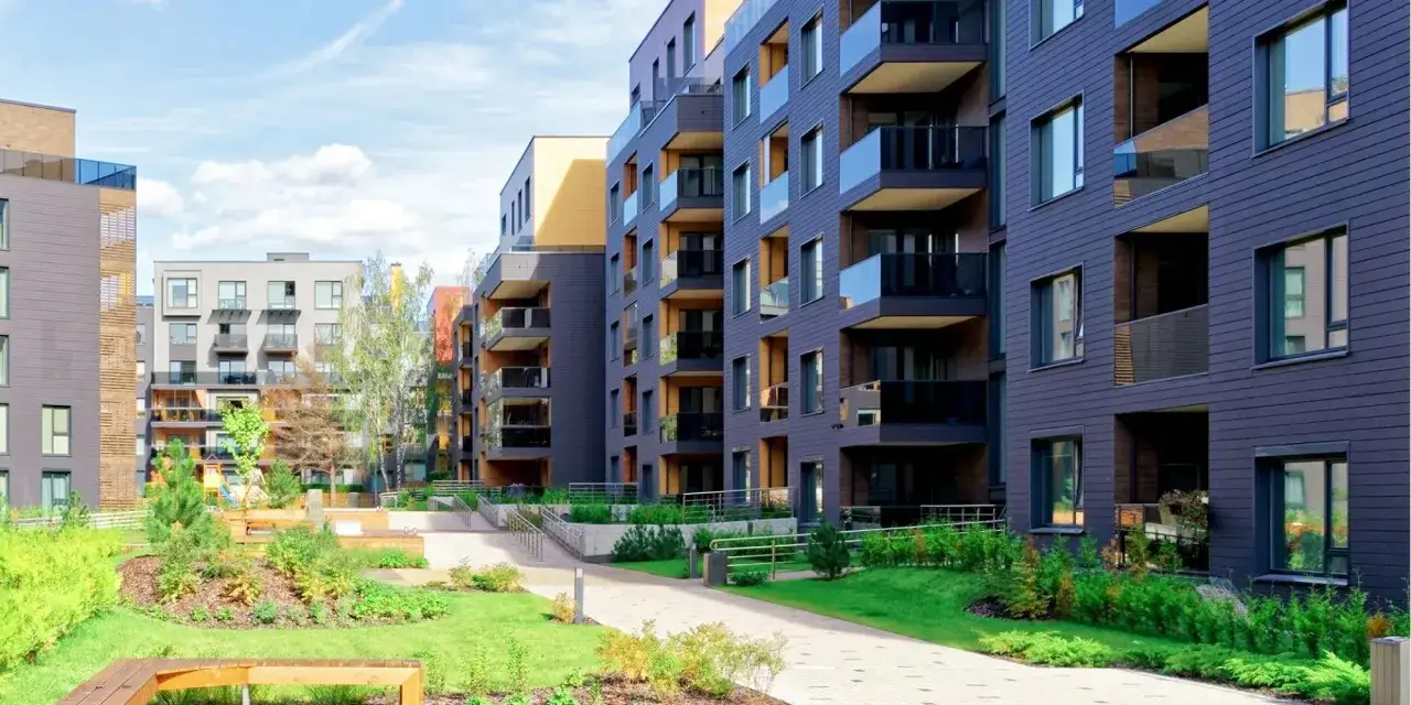 Immeubles modernes avec balcons vitr&eacute;s et espaces verts. Id&eacute;al pour signaler un probl&egrave;me au syndic concernant l'entretien du jardin.