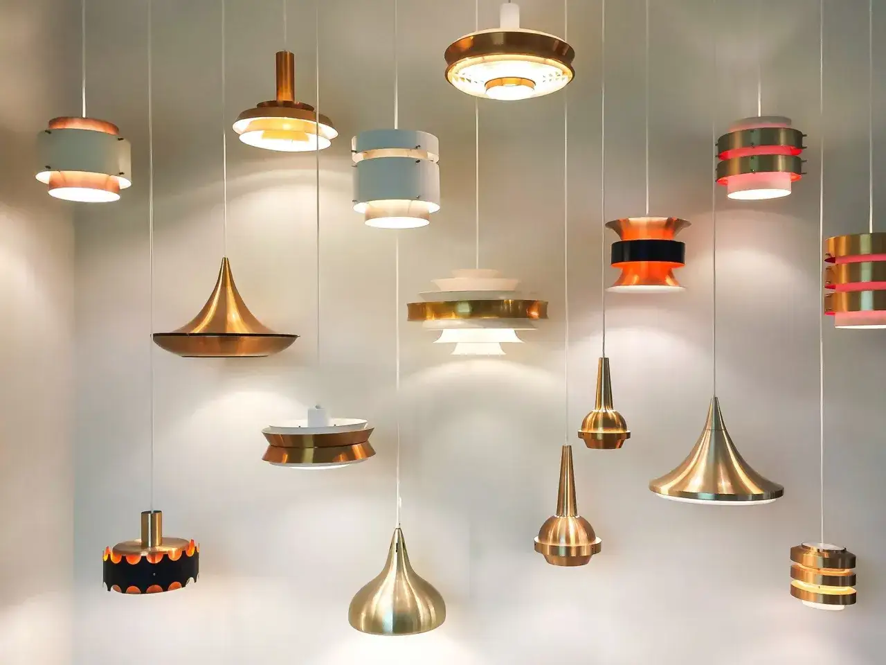 Collection de suspensions design aux formes vari&eacute;es, diffusant une **lumi&egrave;re chaude** et accueillante.