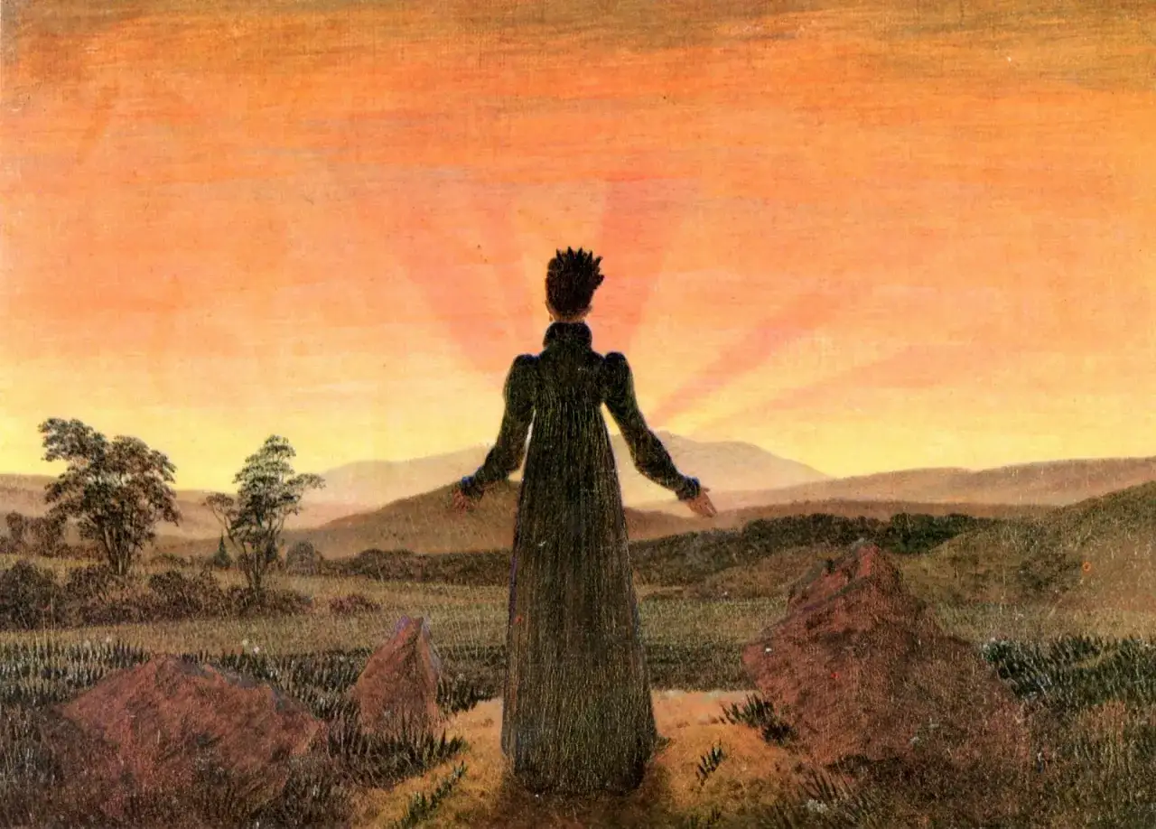 Une silhouette se tient face à un soleil couchant victor hugo, bras ouverts, dans un paysage de collines et de rochers.