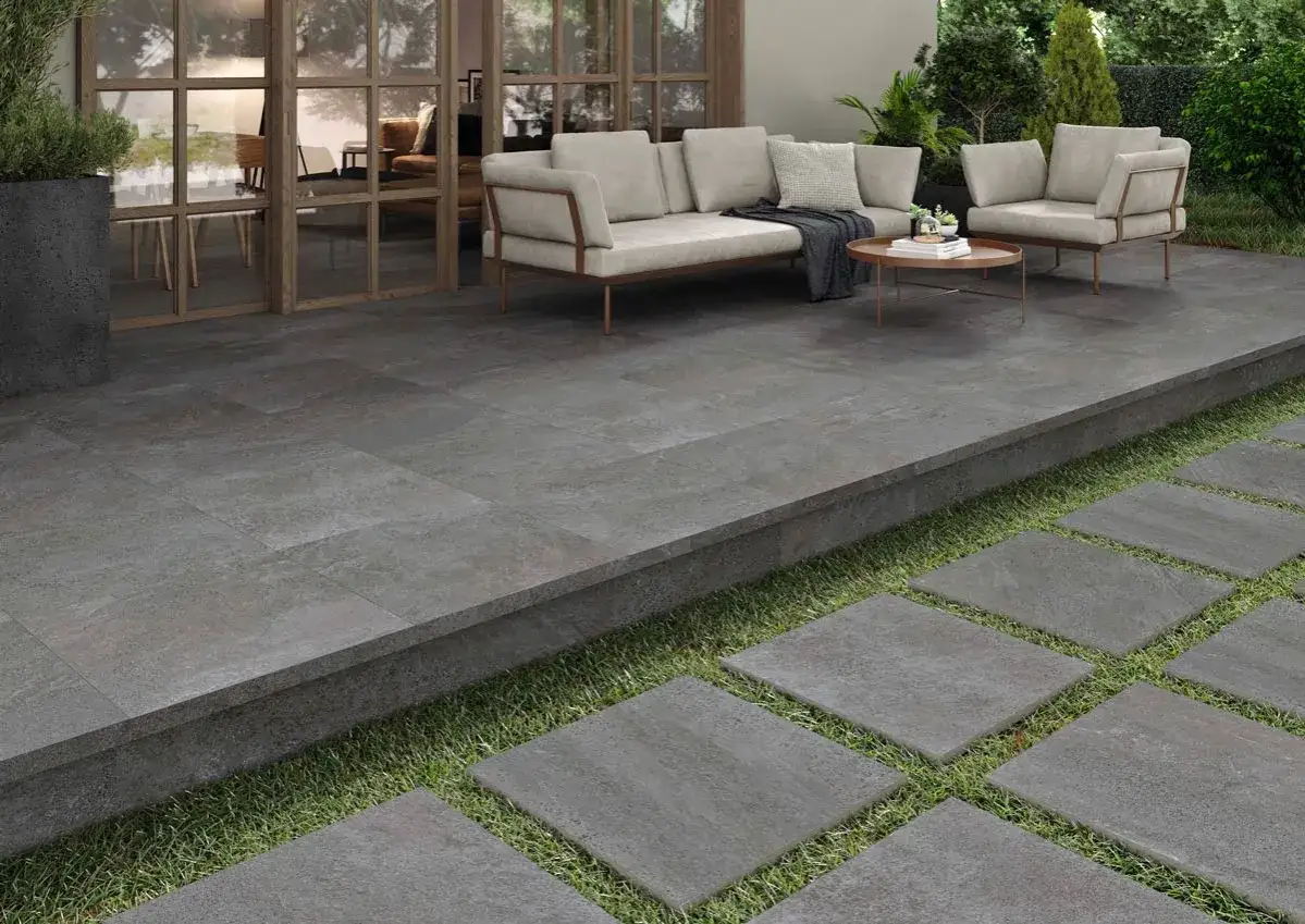 Modern patio with grey stone tiles, perfect for **suelos para jardin sin obra**. Comfortable seating area and garden access.