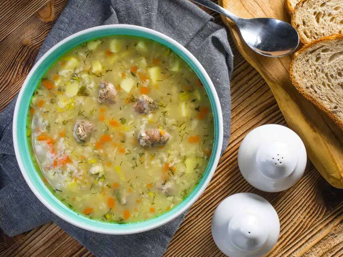 Aromaticzny zupa krupnik przepis babci, pełna ziemniaków, marchewki i mięsa, podana z chlebem.