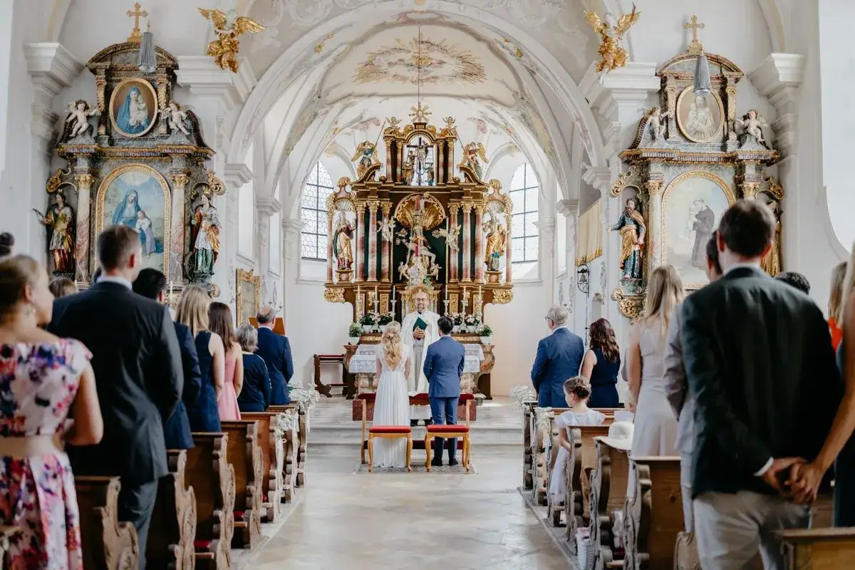 Hochzeit in der Kirche: Brautpaar, Pfarrer und Gäste. Als Trauzeuge muss man hier sein, um dem Paar beizustehen.