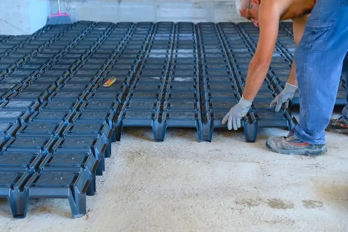 Operaio posa elementi modulari per creare un vespaio pavimento.