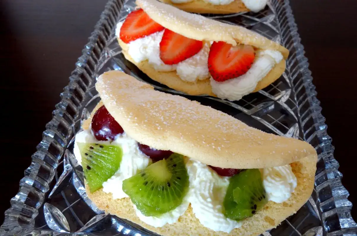 Omlet z bitą śmietaną, truskawkami i kiwi. Delikatne ciasto przełożone kremową śmietaną i świeżymi owocami.