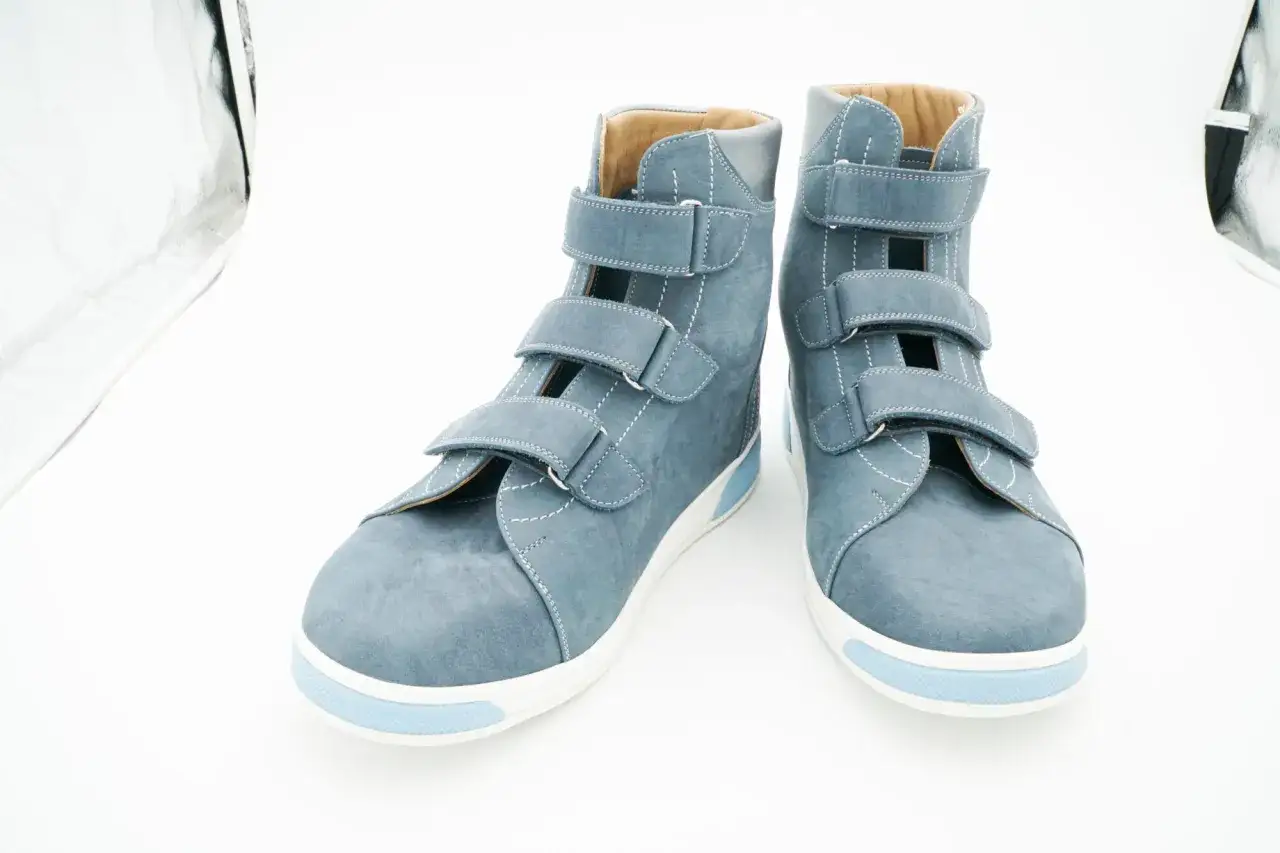 Ein Paar blaue, hohe orthop&auml;dische Schuhe mit Klettverschl&uuml;ssen. Sie zeigen, wie orthop&auml;dische Schuhe aussehen k&ouml;nnen: funktional und doch stilvoll.