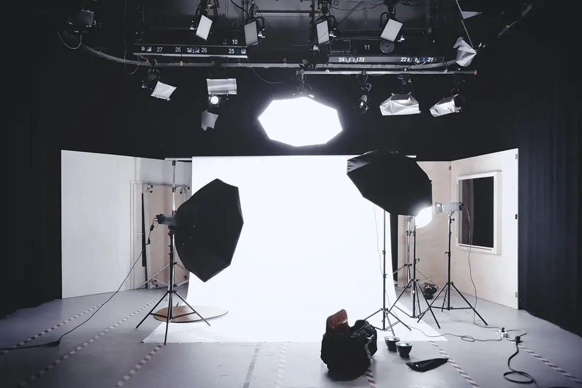 Gotowy plan na dzień fotografa: studio z białym tłem, lampy, parasole i sprzęt.