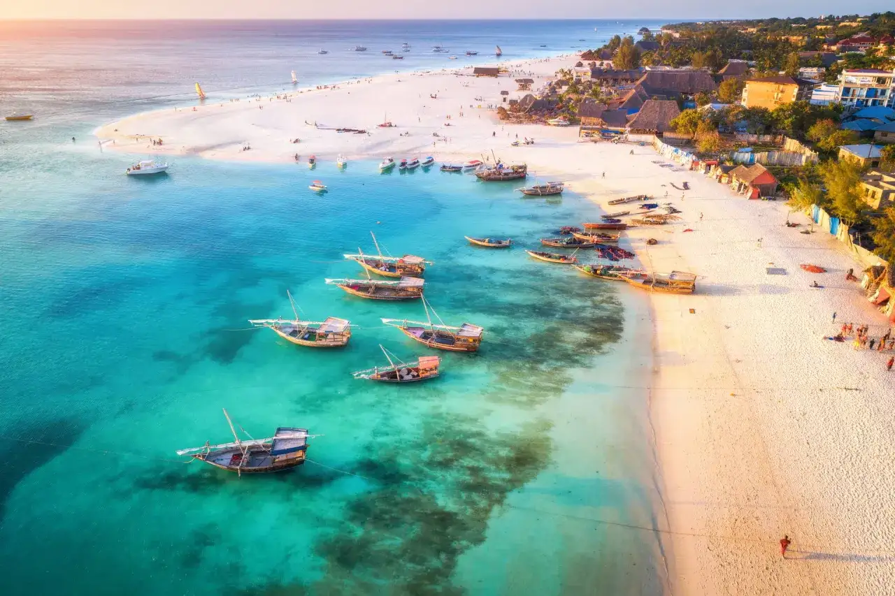 Zanzibar wycieczki fakultatywne: łodzie dhow na turkusowej wodzie, biała plaża i palmy. Idealne miejsce na wakacje.