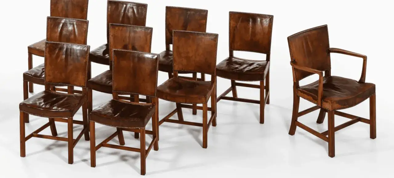 En samling l&auml;derkl&auml;dda stolar, inspirerade av Kaare Klints design, med tr&auml;stomme och nitade detaljer.