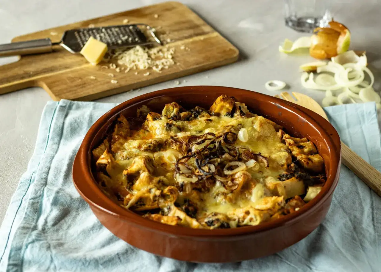 Herzhafter Maultaschen Auflauf mit geschmolzenem Käse und Röstzwiebeln, bereit zum Servieren.