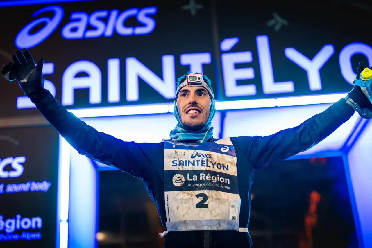 Un coureur célèbre les résultats de la Saintélyon, bras levés, portant le dossard numéro 2.