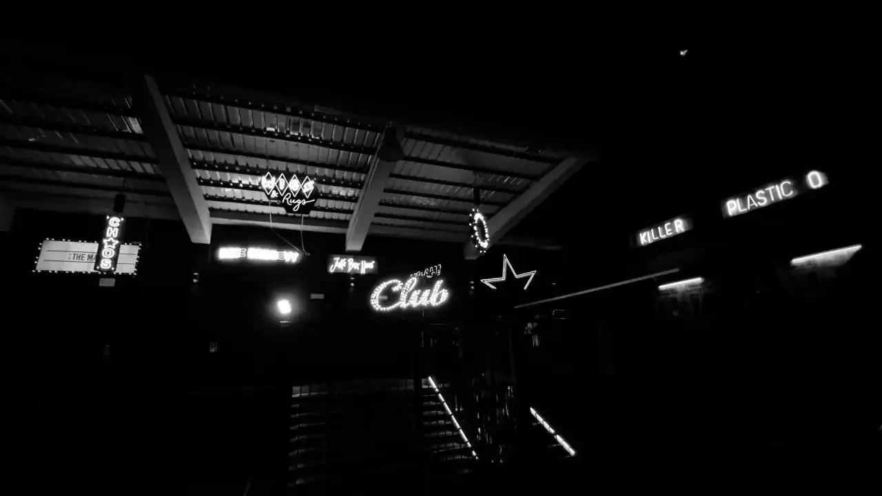 Luci al neon di locali storici milanesi: Chaos, Club, Killer, Plastic. Nomi discoteche anni '70 Milano.