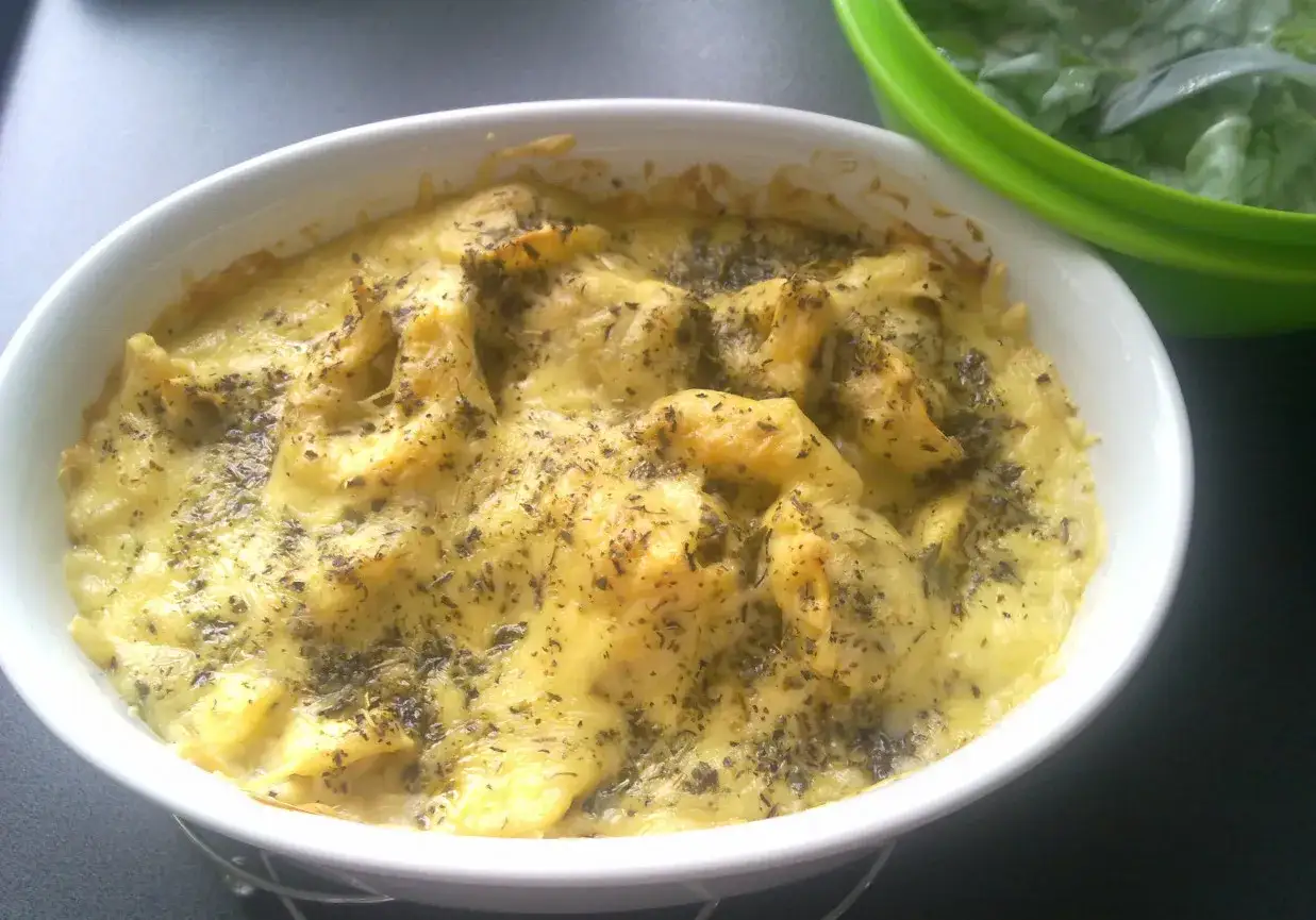 Zapiekane tortellini ze szpinakiem, polane sosem serowym i posypane ziołami. Idealne danie, gdy zastanawiasz się, jak zrobić tortellini ze szpinakiem.