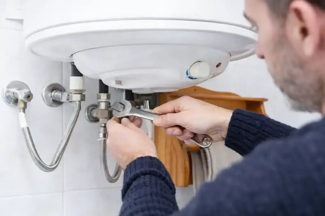 Hombre repara termo el&eacute;ctrico no enciende con llave inglesa.