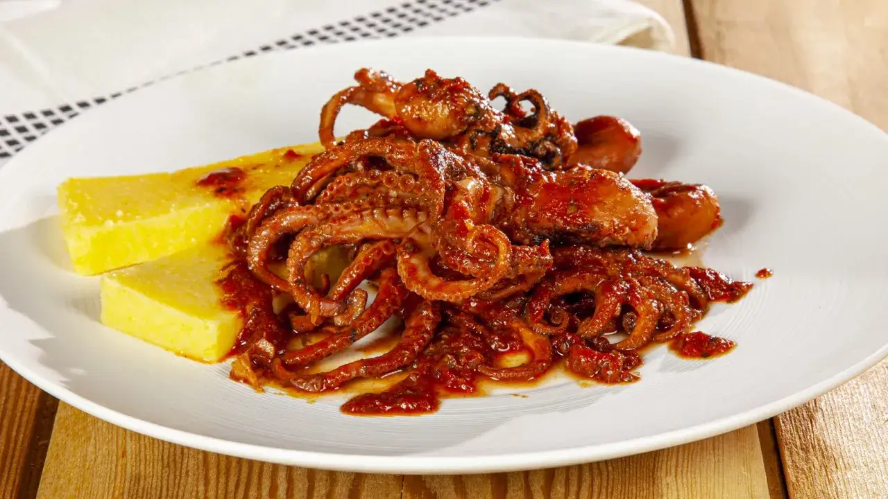 Polipetti in purgatorio, un piatto succulento con tentacoli rossi e polenta gialla, un vero tormento per il palato.