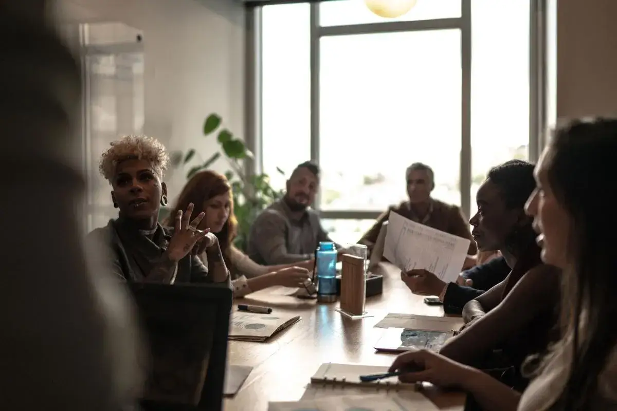 A diverse group of people in a meeting, discussing ideas. This shows why diversity and inclusion are important in society, fostering innovation and understanding.