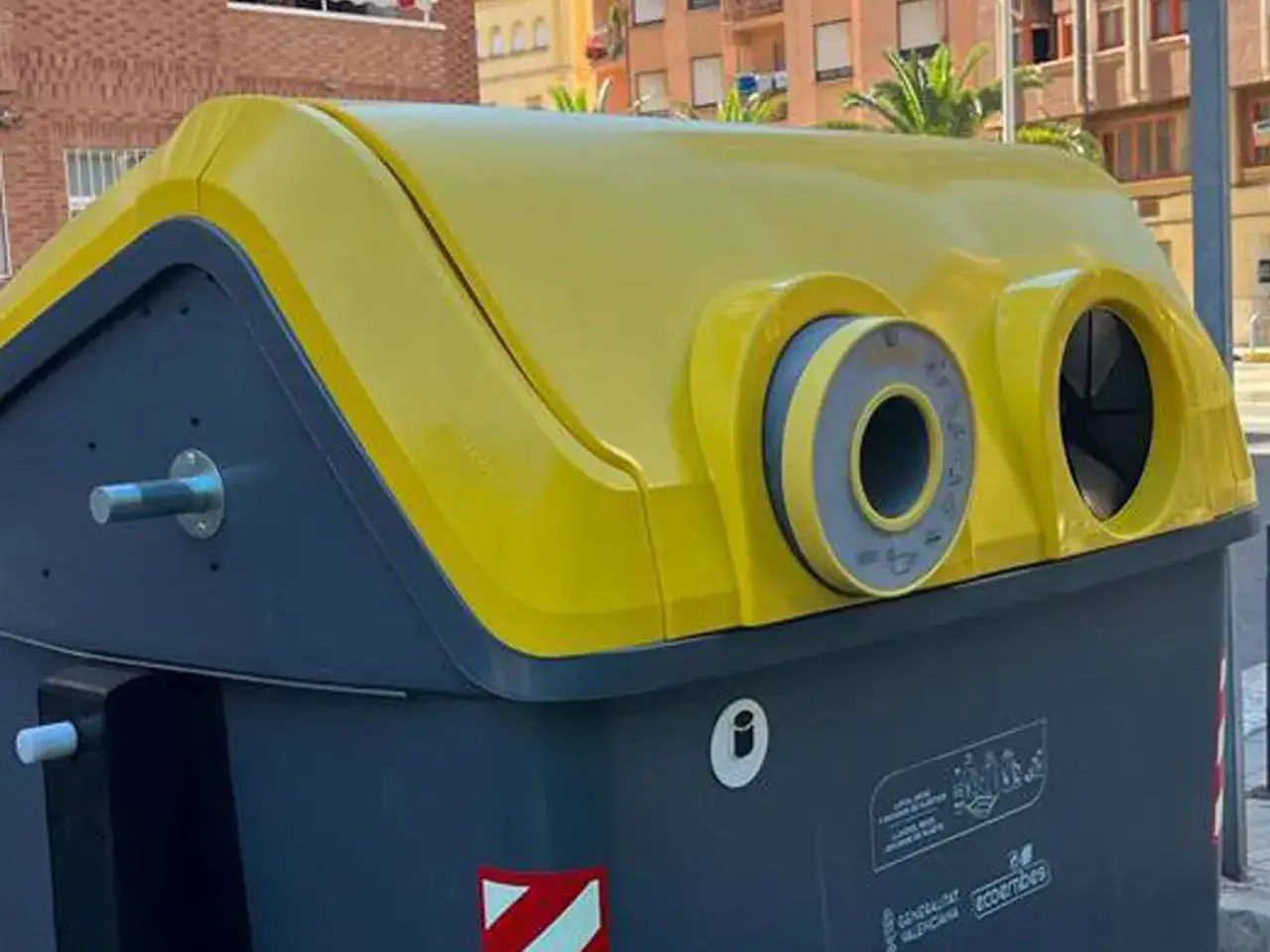 Contenedores de reciclaje de Ecoembes, con tapas amarillas y cuerpos grises, listos para recibir residuos.