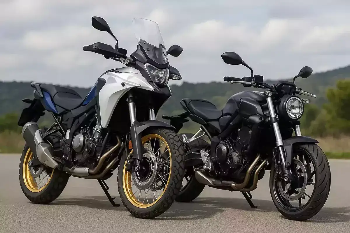 Dos motos en comparativa: una trail blanca y azul con ruedas de radios dorados y una naked negra.