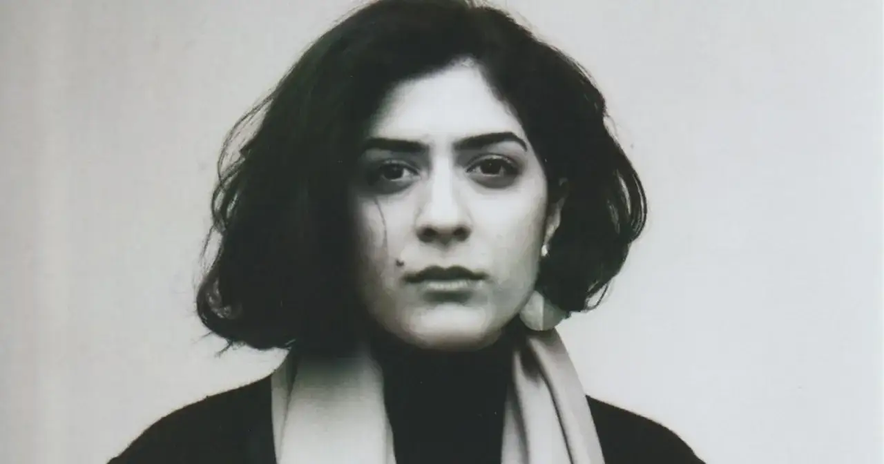 Porträt von Tanasgol Sabbagh, einer jungen Frau mit dunklem Haar und nachdenklichem Blick, die einen Schal trägt.