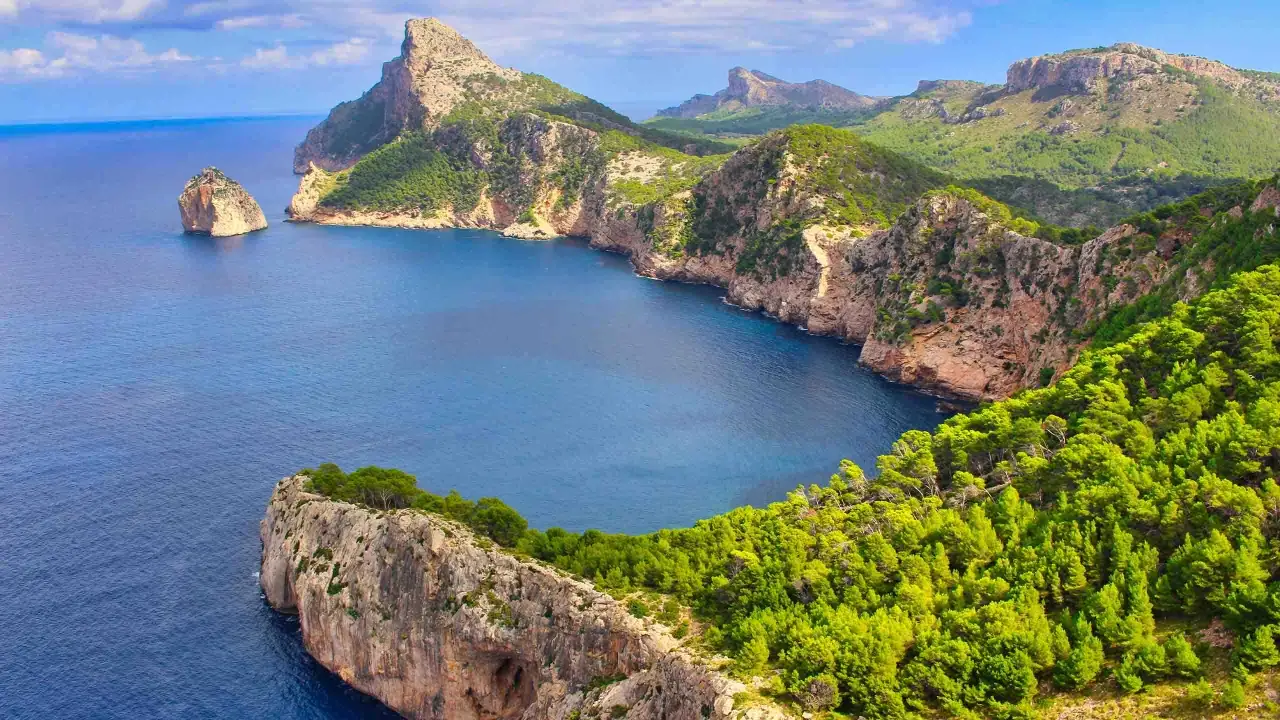 Steile Felsk&uuml;sten mit Pinienw&auml;ldern und t&uuml;rkisfarbenem Meer, ideal f&uuml;r einen fernwanderweg auf Mallorca.