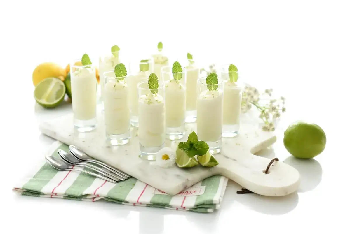 Delicioso mousse de lim&oacute;n Thermomix en vasitos, decorado con menta y ralladura de lim&oacute;n. &iexcl;Perfecto para refrescar!