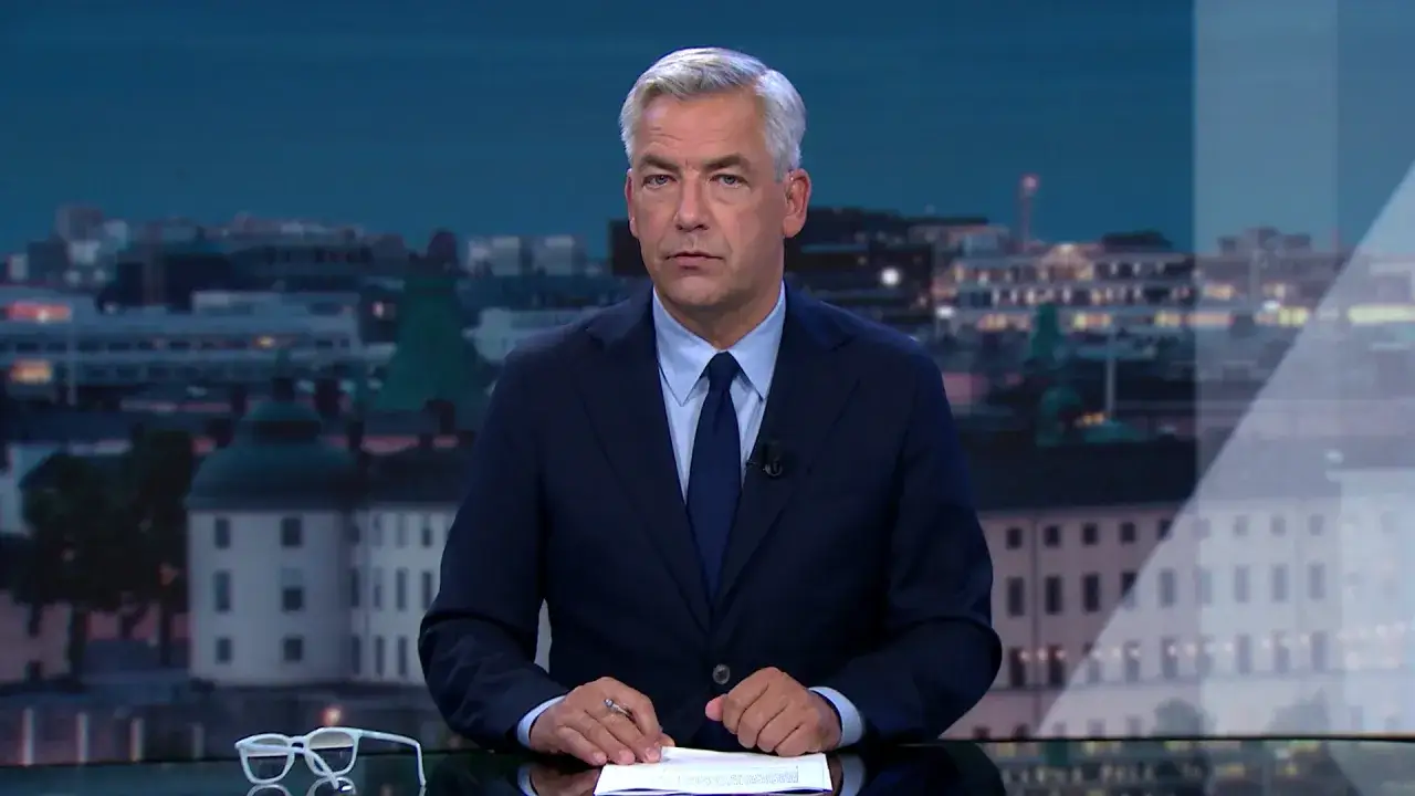 Anders Kraft från TV4 sitter vid ett bord med glasögon och papper framför sig.