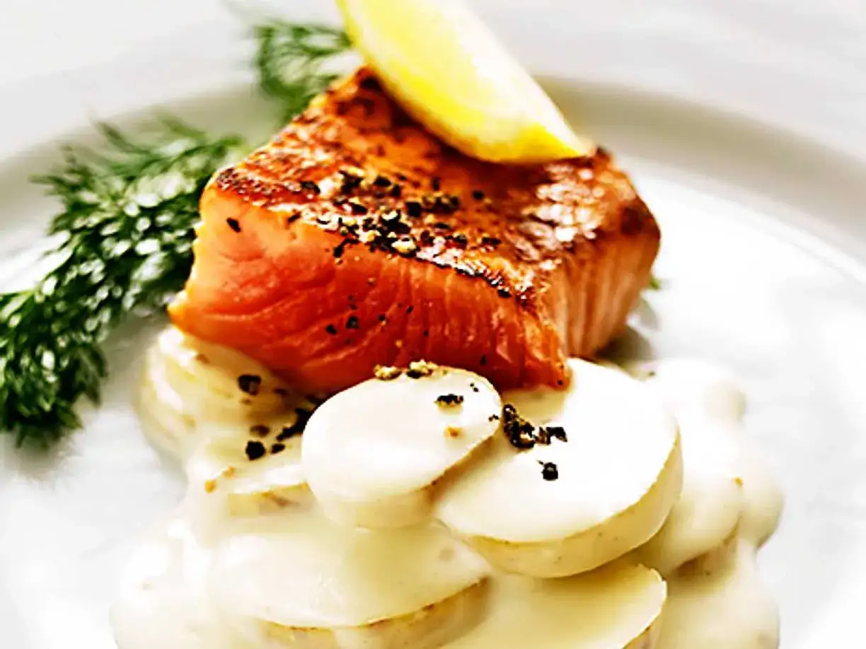 En bit stekt lax med citronskiva och dill, serverad p&aring; potatis med en kr&auml;mig s&aring;s. Perfekt till ditt gravlaxs&aring;s recept.